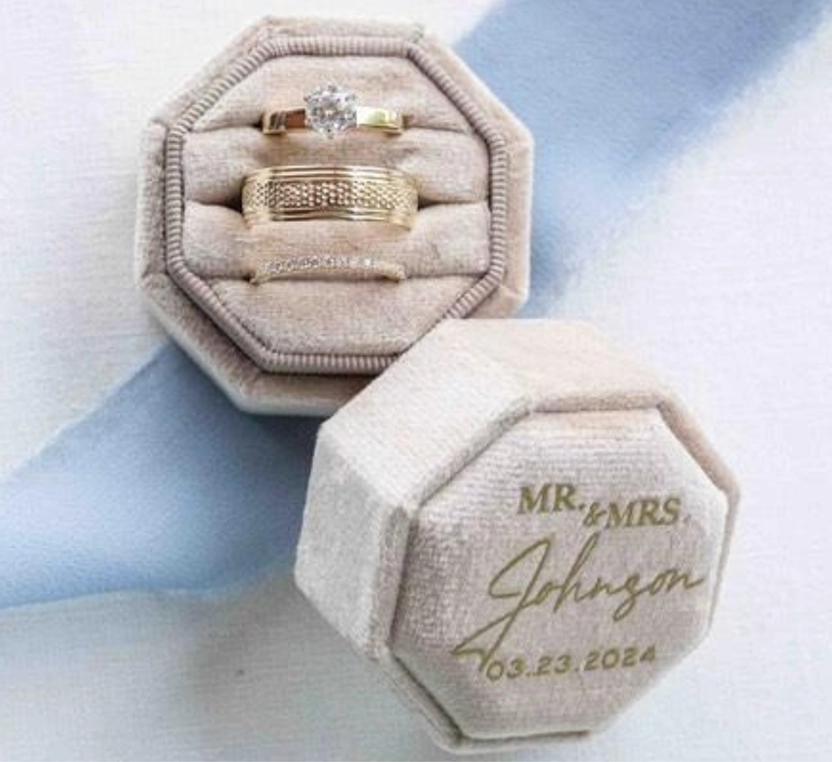 Ring box with wedding rings and 'MR & MRS. Johnson' engraving on a light background