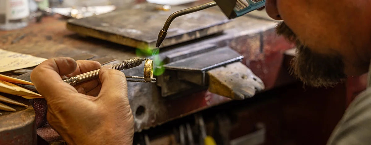 Person working with jewelry on a workbench